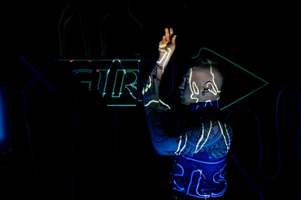 Tattooed man in cyberpunk neon lights at night, embodying a techno vibe.
